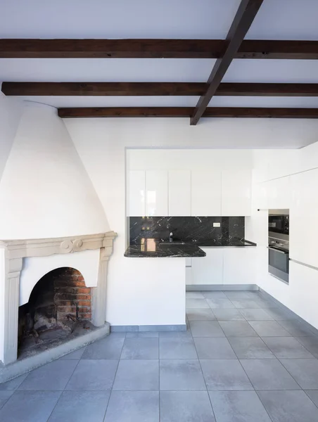 Kuchyň v otevřeném prostoru v blízkosti obývacího pokoje s krbem — Stock fotografie