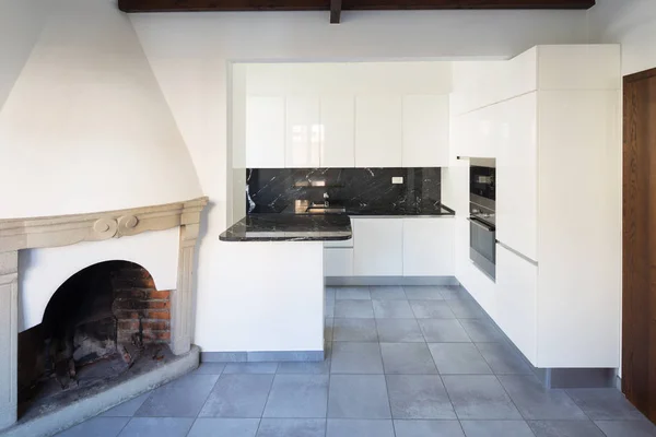 Kitchen in open space near living room with fireplace — Stock Photo, Image