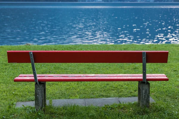 Red bench at lake shore — Stock Photo, Image