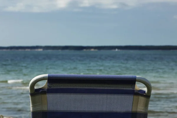 De eenzaamheid van de leerstoel aan het strand — Stockfoto