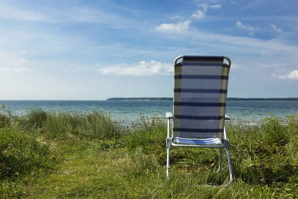 De eenzaamheid van de leerstoel aan het strand — Stockfoto