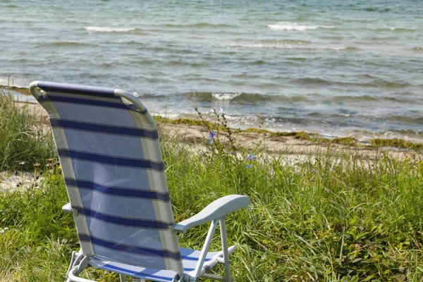 De eenzaamheid van de leerstoel aan het strand — Stockfoto