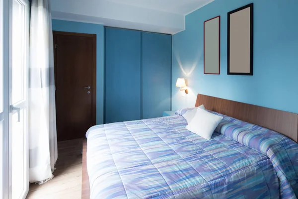 Blaues Schlafzimmer mit Rahmen an der Wand — Stockfoto