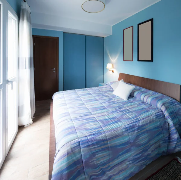 Blaues Schlafzimmer mit Rahmen an der Wand — Stockfoto