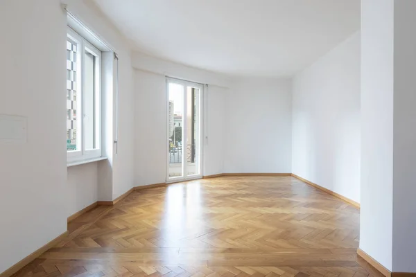 Habitación vacía en un apartamento con paredes blancas y suelos de madera — Foto de Stock