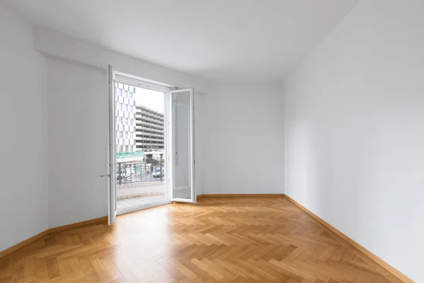 Leeres Zimmer in einer Wohnung mit weißen Wänden und Holzböden — Stockfoto