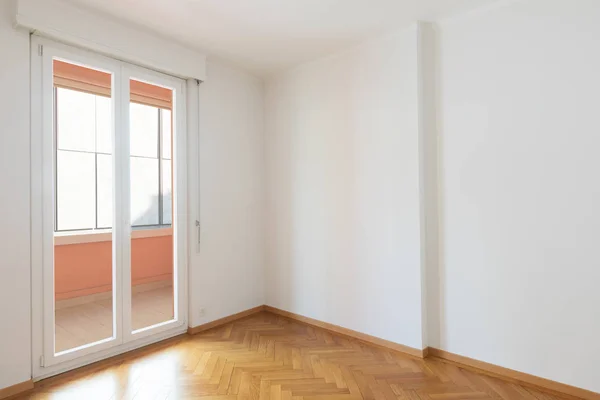 Habitación vacía en un apartamento con paredes blancas y suelos de madera — Foto de Stock