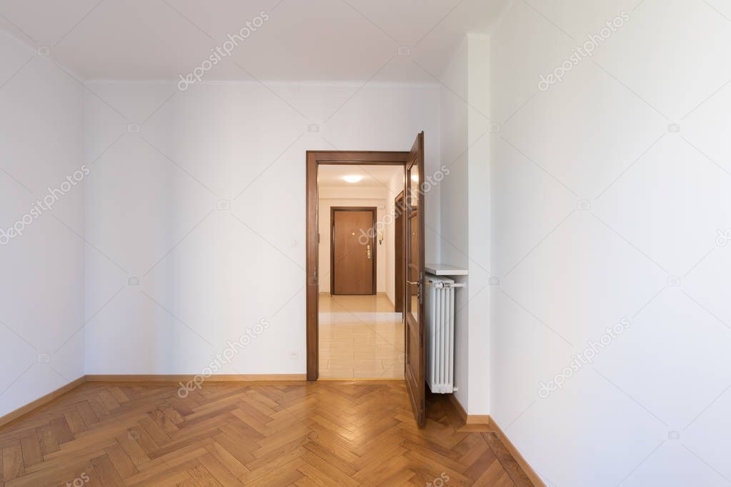 Empty room in a apartment with white walls and wooden floors