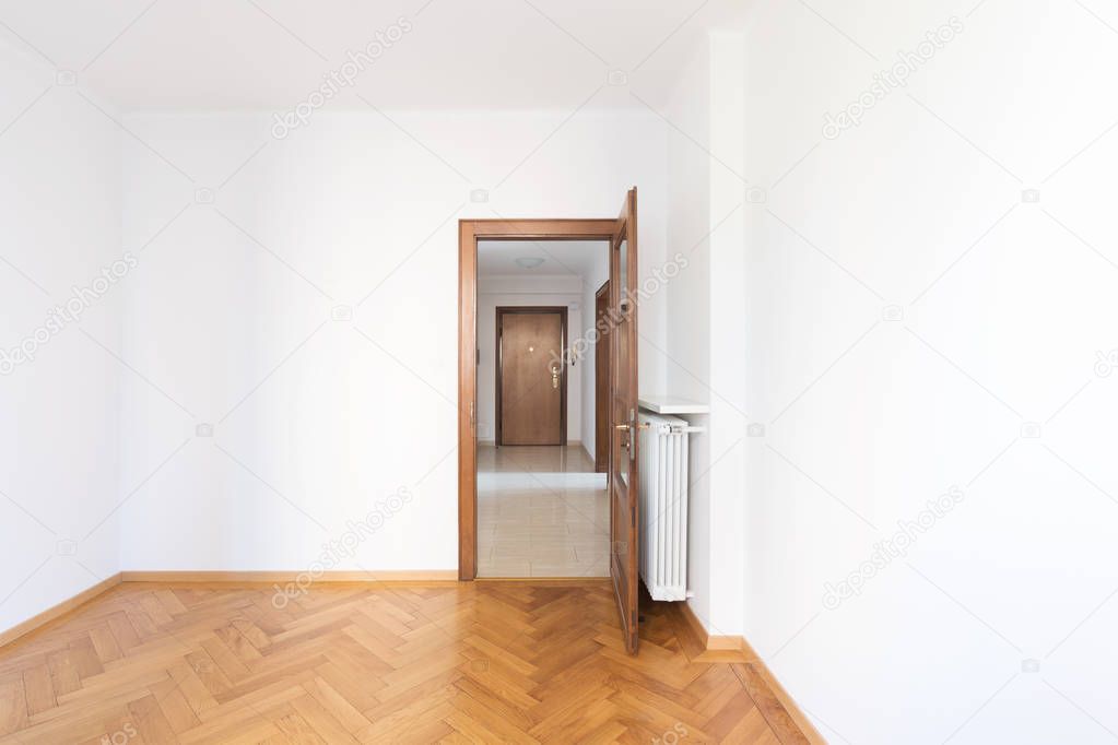 Empty room in a apartment with white walls and wooden floors