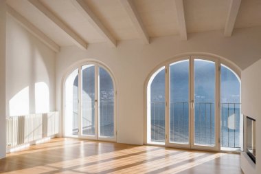 Büyük pencereler ve antik kirişler boş oda