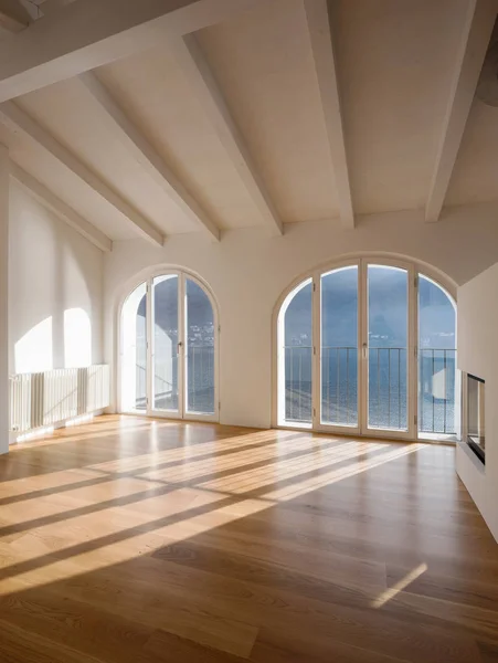 Chambre vide avec grandes fenêtres et poutres anciennes — Photo