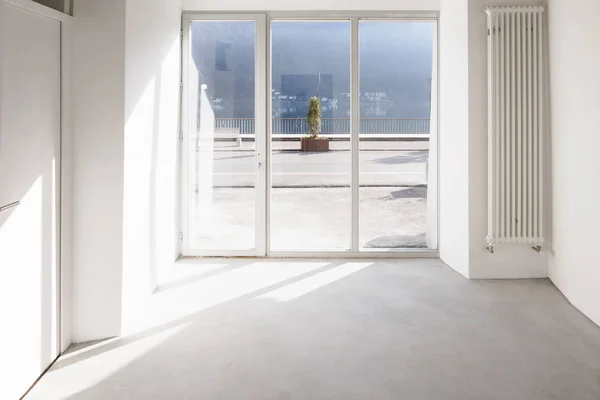 Tyhjä huone, jossa suuret ikkunat ja antiikkipalkit — kuvapankkivalokuva