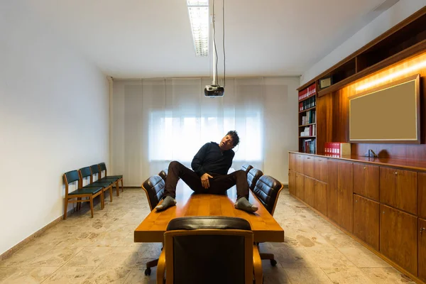 L'homme se touche sur la table de la salle de réunion — Photo