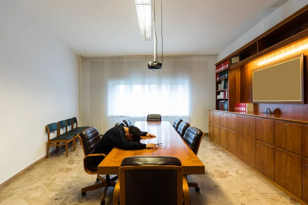 Homem solitário na sala de reuniões está dormindo — Fotografia de Stock