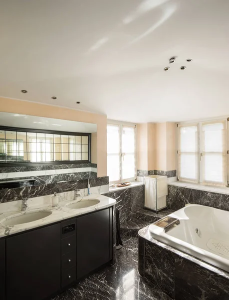 Bathroom with black marble tiles and empty big bathtub — Stock Photo, Image