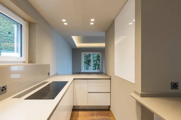Cozinha com mobiliário branco moderno e aparelho de última geração — Fotografia de Stock