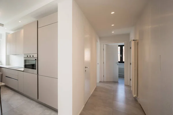 Elegante cozinha e corredor com holofotes no apartamento moderno — Fotografia de Stock