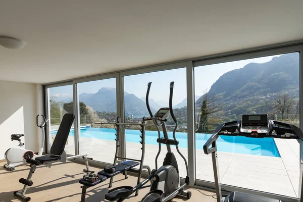 Fitnessraum mit Blick auf den Pool und die Hügel — Stockfoto
