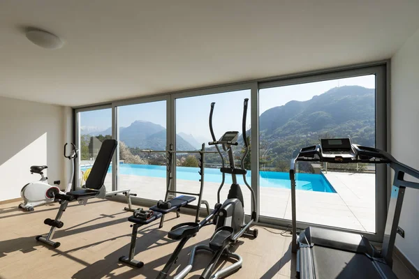 Fitnessraum mit Blick auf den Pool und die Hügel — Stockfoto