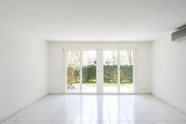 Große Fenster mit Blick auf den Garten in einem völlig leeren Raum — Stockfoto