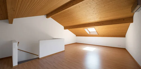 Large attic with wooden floors and exposed beams — Stock Photo, Image