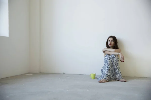 Mädchen Sitzt Mit Gelbem Becher Auf Dem Boden Und Denkt — Stockfoto