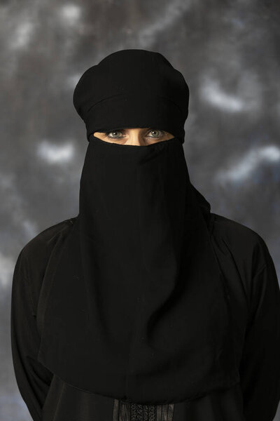 Портрет мусульманки с закрытым лицом. Фотосессия проходила в студии на тёмном фоне. Красивая 50-летняя девушка
.