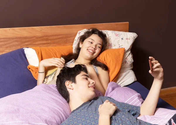 Una Pareja Joven Está Acostada Cama Ambos Miran Teléfono Mientras —  Fotos de Stock