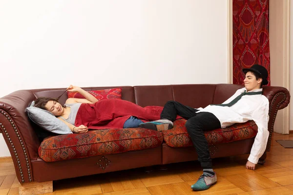 若いカップルはソファの上に横たわっていた 彼女は毛布で覆われている 実業家 — ストック写真