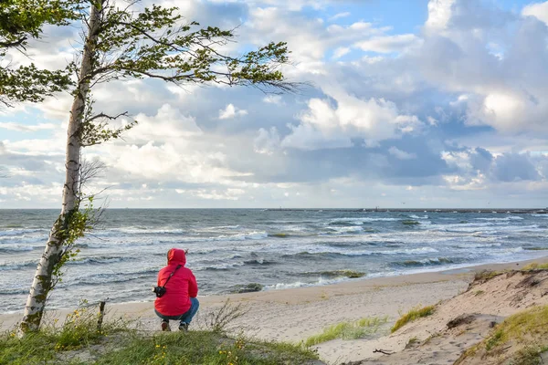 Fille est assise sur le front de mer et regarde dans la distance — Photo