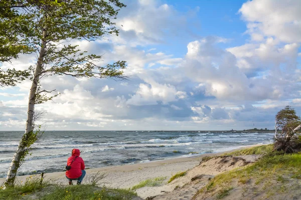 Fille est assise sur la plage regardant vers l'horizon — Photo