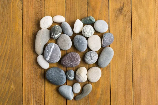 Ahşap tahta arka plan üzerinde taş kalp