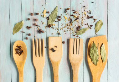 Ahşap mutfak gereçleri ve eski bir tablo üzerinde çeşitli baharatlar