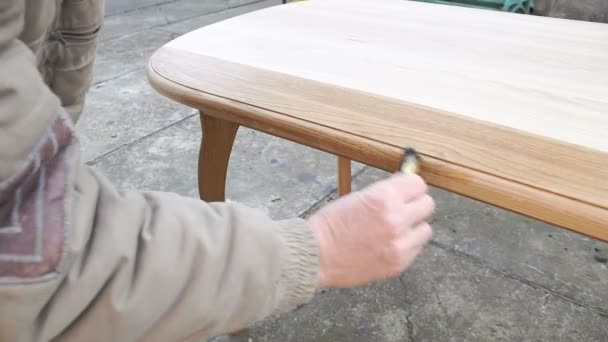 Carpenter je pokrývá tabulku o lak — Stock video