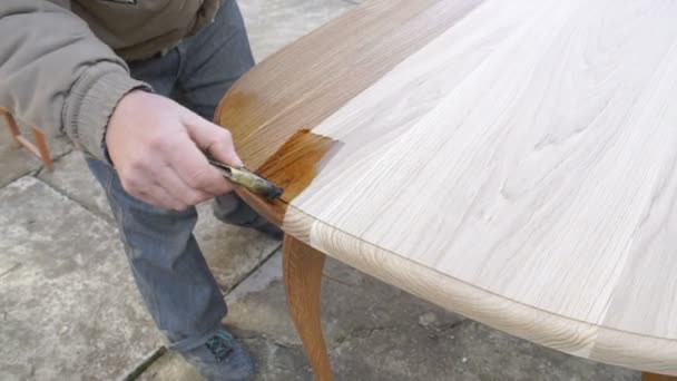 Carpenter is covering table by lacquer — Stock Video
