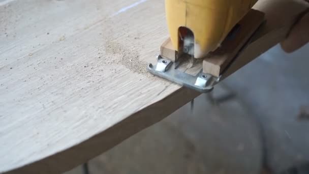 Carpintero está cortando una tabla con sierra de calar — Vídeo de stock