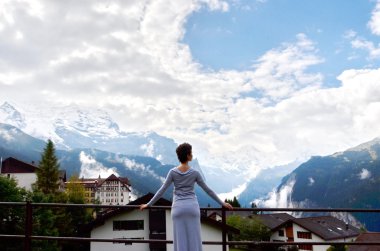 Uzun gri elbiseli, dağ manzaralı genç bir kadının portresi. Arka plan kadın portresi