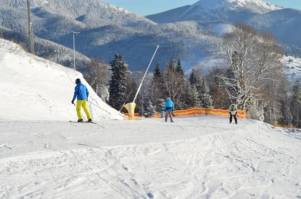 Paisaje invernal con árboles cubiertos de nieve. esquiadores en pista de esquí —  Fotos de Stock