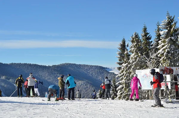 Snowboarders e esquiadores no topo da encosta da montanha . — Fotografia de Stock