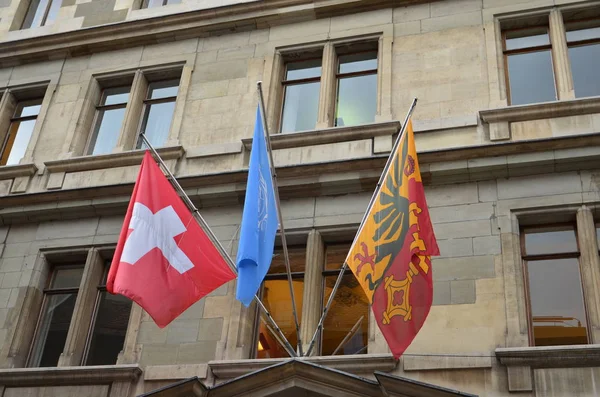 Banderas suizas nacionales y de la ciudad montadas en la pared de la casa vieja —  Fotos de Stock
