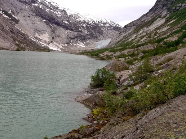 Hierba verde, lago y fondo de montaña. Lago en las montañas — Foto de Stock