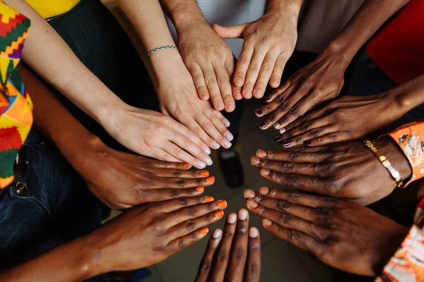 Hände einer glücklichen Gruppe multinationaler afrikanischer, lateinamerikanischer und europäischer Menschen, die im Kreis zusammenbleiben — Stockfoto