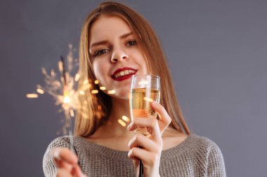 Çekici, neşeli, uzun açık renk saçlı, gülümseyen bir kız.