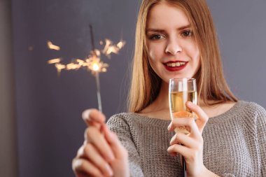 Güzel Bengal lambası ve bir kadeh şampanya Bir kadının ellerinde