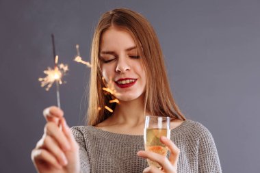 Çekici, neşeli, uzun açık renk saçlı, gülümseyen bir kız.