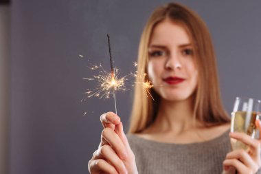 Çekici, neşeli, uzun açık renk saçlı, gülümseyen bir kız.