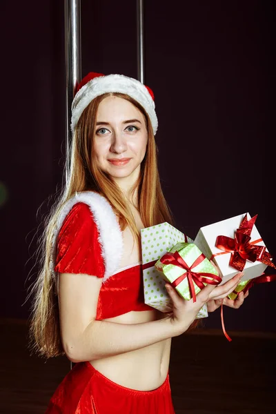 Imagen de alegre santa helper strip-tease chica con muchos regalos —  Fotos de Stock