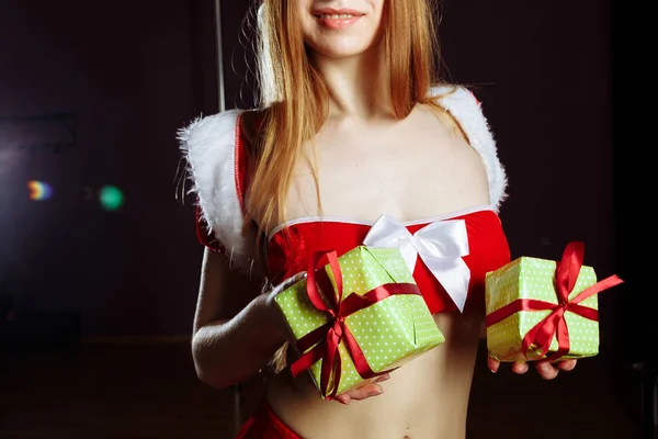 Linda ruiva tira-tease menina em um vestido e chapéu de Santa é s — Fotografia de Stock