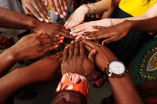 Mãos de grupo feliz de povos africanos, latino-americanos e europeus multinacionais que permanecem juntos em círculo — Fotografia de Stock