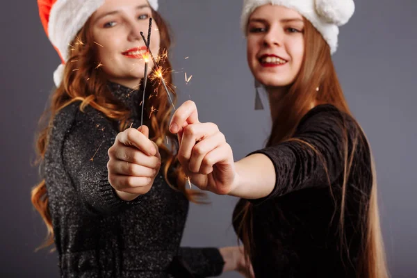 Hanımlar kameraya bakıyor ve gülümsüyor, gri renkte izole bir şekilde.